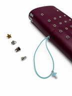 Burgundy full size journal displayed with a powder-blue elastic band, blue mushroom band charm, and removable KEPT cover charms arranged beside the journal.