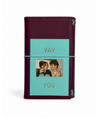 Burgundy full size journal styled with the double-sided gold-foil “Yay You” photo keepsake card beneath the powder-blue elastic band.