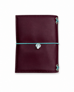 Back view of the Burgundy pocket journal with a powder-blue elastic closure and mushroom band charm