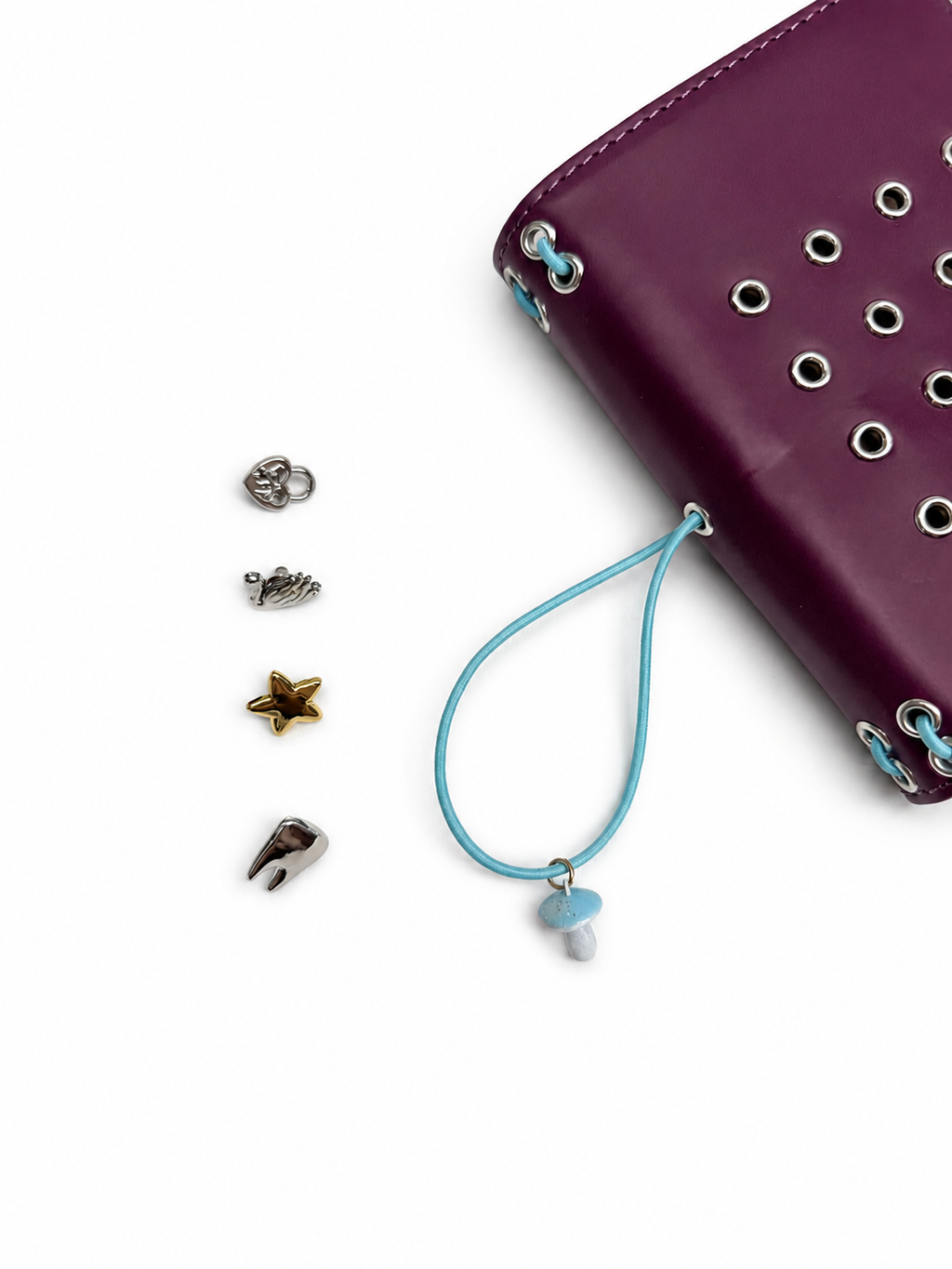 Burgundy pocket journal displayed flat with four removable KEPT cover charms placed beside it