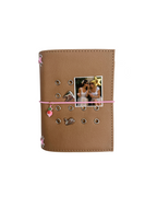 Front view of the Camel Radish Pocket Journal with a textured PU cover, blush-pink elastic band, pink radish charm, metal eyelets, and four removable KEPT cover charms.