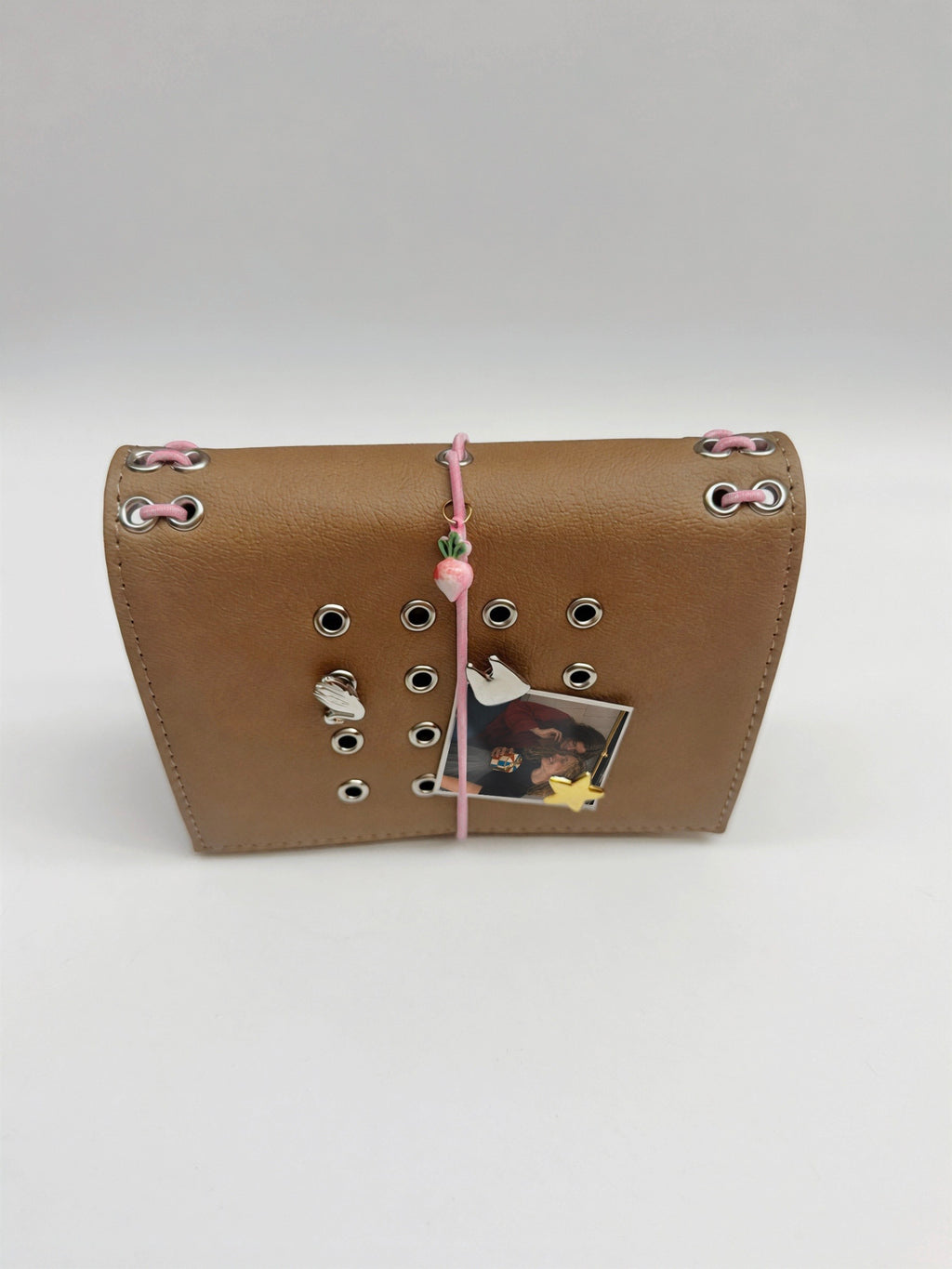 Camel pocket journal with a pink elastic band, radish charm, removable metal cover charms, and a personal photo displayed on the front.