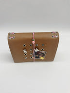 Camel pocket journal with a pink elastic band, radish charm, removable metal cover charms, and a personal photo displayed on the front.