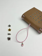 Camel Radish Pocket Journal displayed beside its blush-pink elastic band and four removable KEPT cover charms on a white background.
