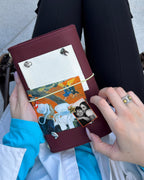 A person holds an Chestnut Fox Full Size Journal decorated with a butter-yellow elastic band, fox charm, removable KEPT cover charms, a portrait photo, and colorful paper keepsakes.