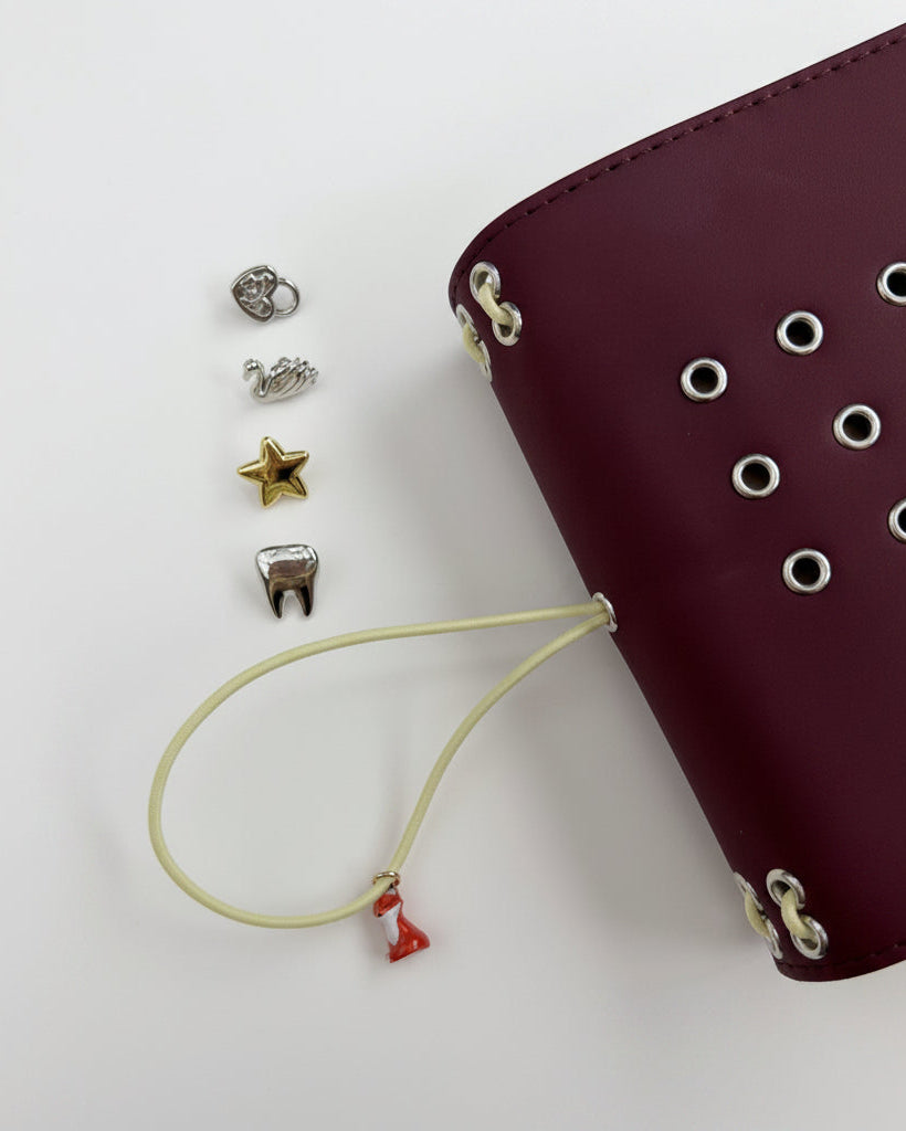 Chestnut Fox pocket journal shown with its butter-yellow elastic band, fox charm, and removable KEPT cover charms displayed beside it
