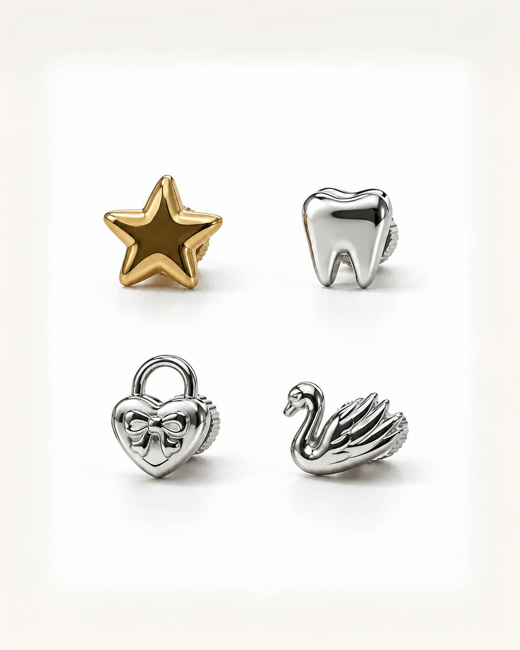 Four small metallic charms arranged on a clean white background: a gold star, a silver tooth, a silver heart-shaped padlock with a bow, and a silver swan.