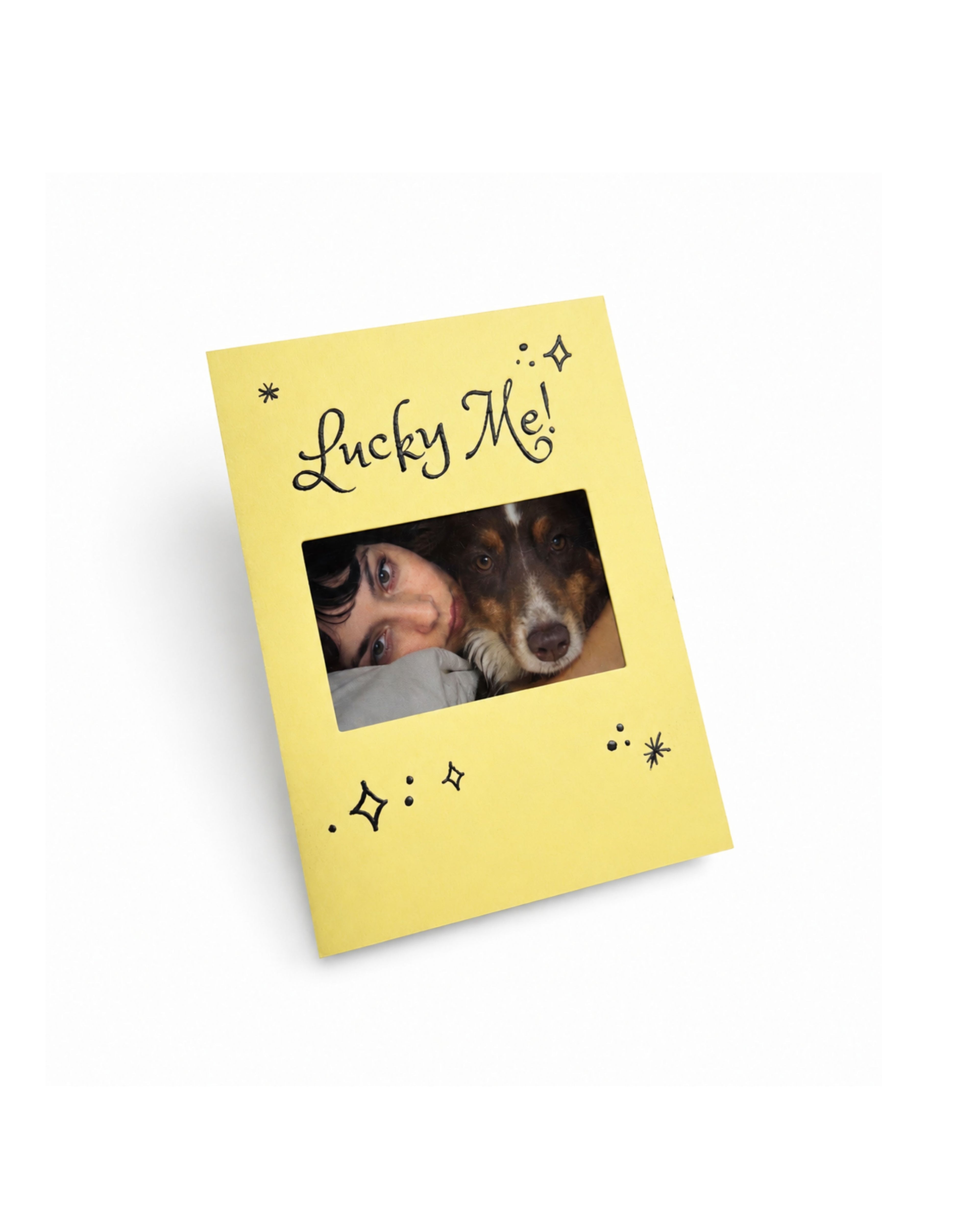 Yellow KEPT photo keepsake card with black “Lucky Me!” lettering and celestial details, featuring a personal photo with a dog in the center.