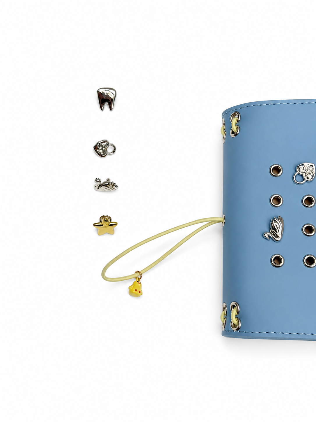 Mist Blue pocket journal displayed with its removable KEPT cover charms and butter-yellow elastic band