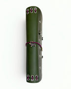 Olive full size journal shown from the side with burgundy cord binding, silver eyelets, dachshund charm, and removable KEPT cover charms.