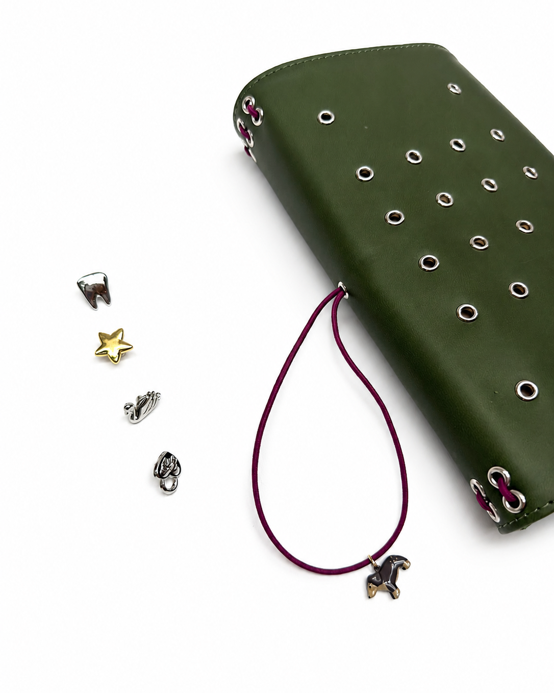 Spine view of the Olive full size journal showing burgundy lacing, metal eyelets, elastic band, and dachshund charm.