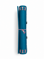 Side view of the Teal Full Size Journal showing its refillable inserts, blush-pink elastic band, pink scissors charm, and metal eyelet binding.