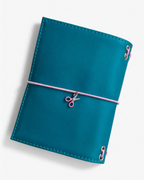 Back view of the Teal pocket journal with a blush-pink elastic band and pink scissors charm