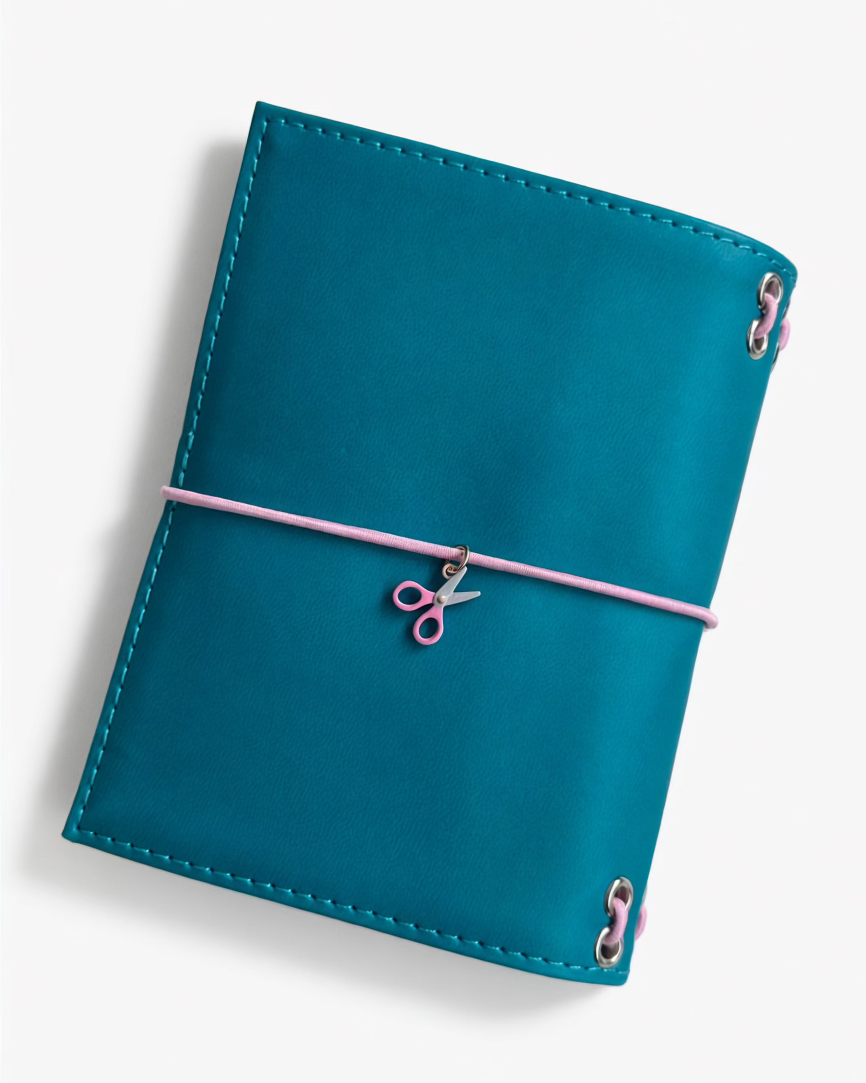 Back view of the Teal pocket journal with a blush-pink elastic band and pink scissors charm
